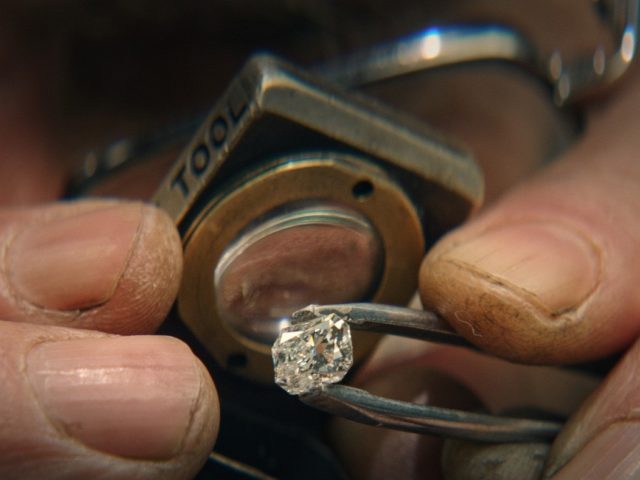 Someone closely examines a diamond