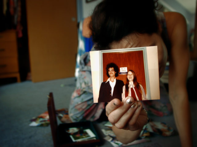A woman holds a picture of her family