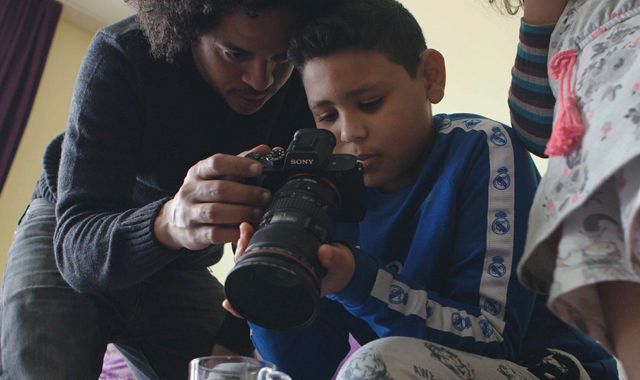A still from Subject. A boy looks at his camera