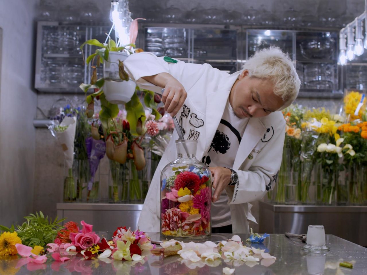 a man in a lab filled with flowers